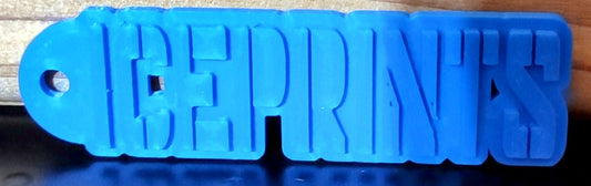 A template as to what the shape of the keychain will be. You can add any appropriate one-word text you would like as this is a custom item. This picture contains a keychain with my company name (Ice Prints) on it.